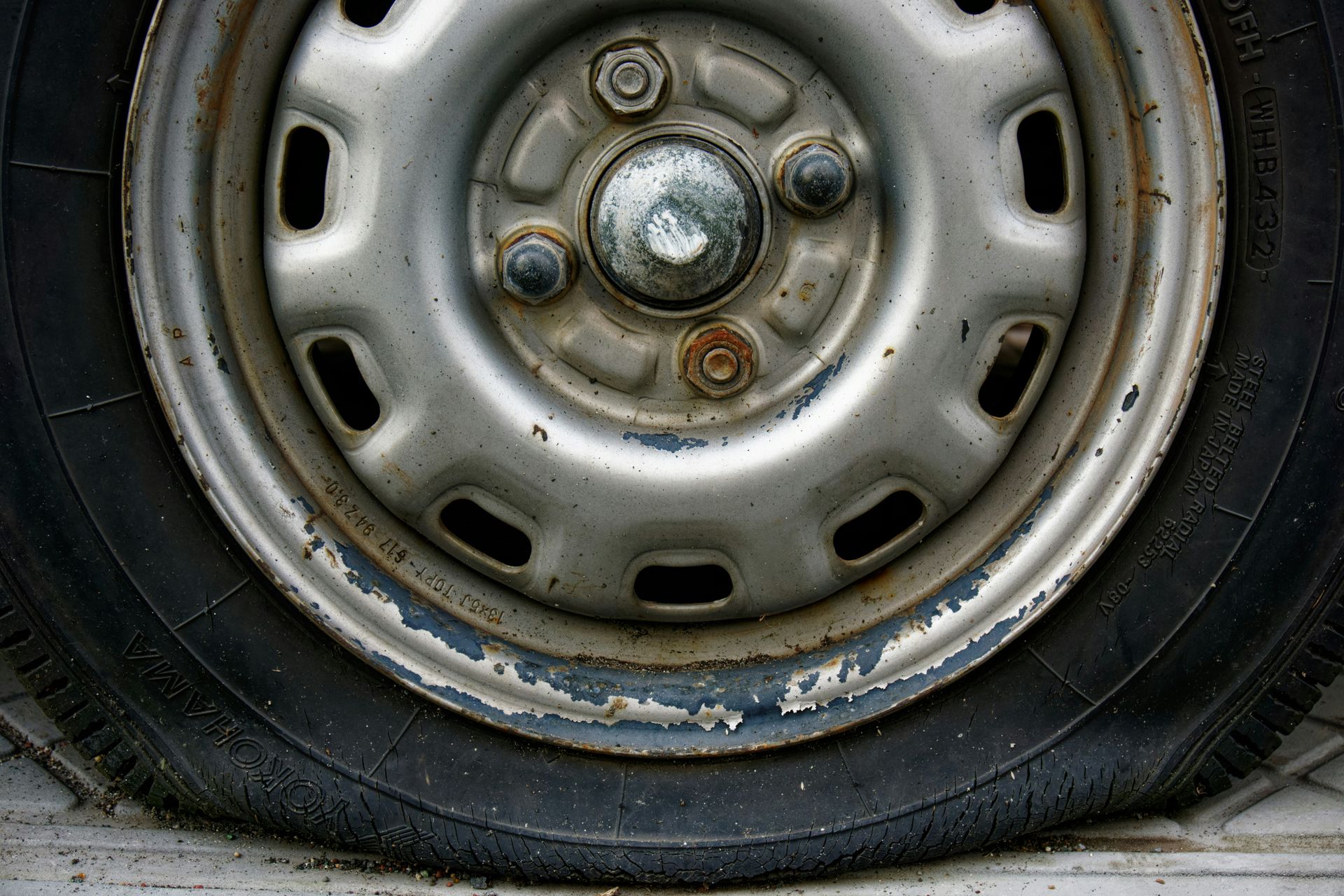 Close-up of a worn car tire and rim